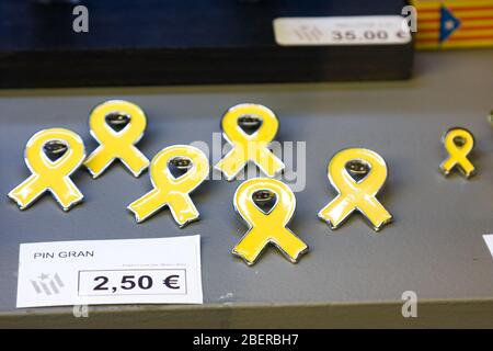 Girona, Spanien - 24.2020: Gelbes Farbband - Symbol der Unabhängigkeit Kataloniens. Metallabzeichen in unterschiedlicher Größe im Schaufenster. Katalanische Unabhängigkeit Stockfoto