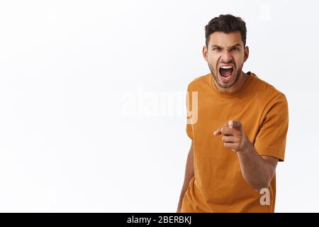 Wütend, verzweifelt empört jungen Mann mit Bart, verlieren Temperament und beschuldigen jemanden, Fluchen, sagen unhöfliche Worte während der Diskussion, zeigen Kamera als Stockfoto