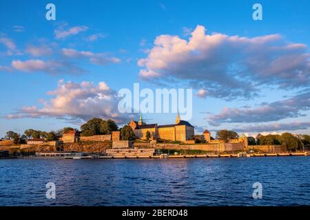 Oslo, Ostlandet / Norwegen - 2019/09/02: Sonnenuntergang Blick auf mittelalterliche Akershus Festung - Akershus Festning - historische königliche Residenz am Oslofjorden Meer sho Stockfoto