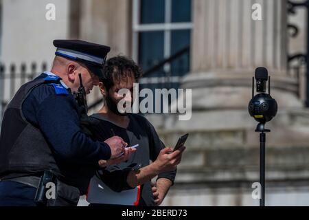London, Großbritannien. April 2020. Die Leute halten an, um Fotos von einem ziemlich ruhigen Trafalgar Square zu machen, während sie auf ihrer täglichen Übung unterwegs sind - die "Sperre" geht in London wegen des Coronavirus (Covid 19) Ausbruchs weiter. Kredit: Guy Bell/Alamy Live News Stockfoto