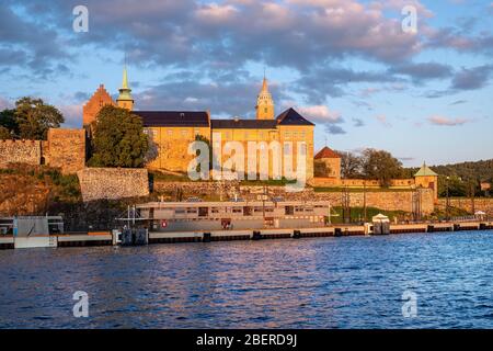 Oslo, Ostlandet / Norwegen - 2019/09/02: Sonnenuntergang Blick auf mittelalterliche Akershus Festung - Akershus Festning - historische königliche Residenz am Oslofjorden Meer sho Stockfoto