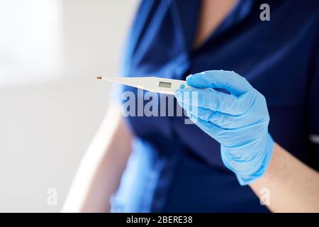 Krankenschwester-Holding-thermometer Stockfoto