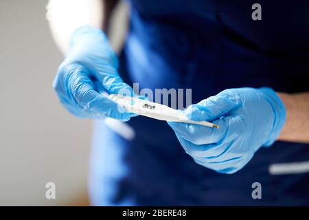 Krankenschwester-Holding-thermometer Stockfoto