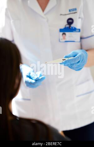 Krankenschwester-Holding-thermometer Stockfoto