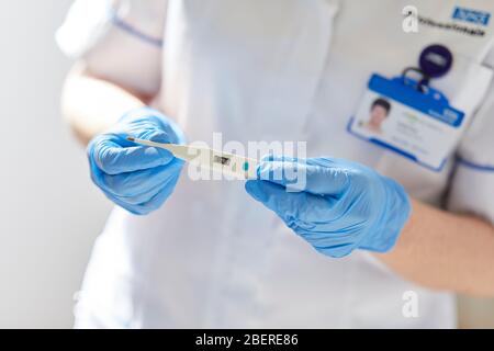 Krankenschwester-Holding-thermometer Stockfoto