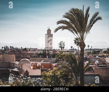 Panoramablick auf den Sonnenuntergang von Marrakesch Mdina und die schneebedeckten Atlasberge in Marokko. Blick auf die Dächer von Marrakesch in der Nähe des Stadtzentrums Stockfoto