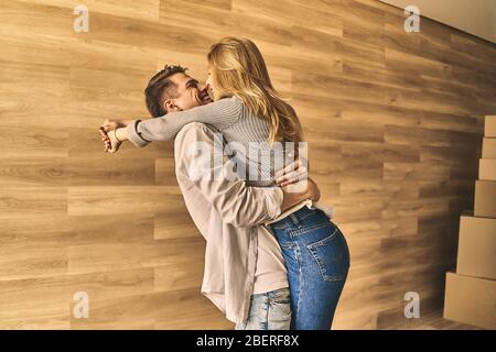 Attraktives junges Paar, das sich ausruhen und sich nach dem Umzug in ein neues Haus freuen kann. Stockfoto