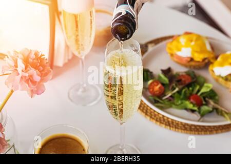 Am sonntagsbrunch Sekt in ein Glas gießen Stockfoto