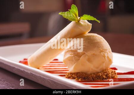 Vanille Eis mit Nüssen und Erdbeersirup Stockfoto