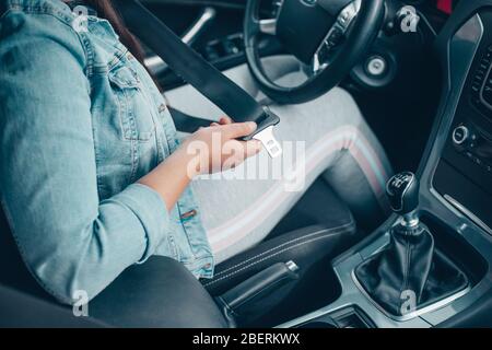 Fahrerfrau, die den Sicherheitsgurt im Auto befestigt, gegen Autounfall, Sicherheitskonzept, sicherer Transport Stockfoto