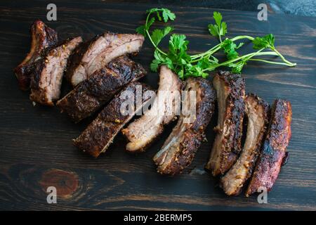 Jamaikanischer Jerker-Schweinefleisch-Rippen:würzige gegrillte Baby-Rücken-Rippen auf einem Holzbrett Stockfoto