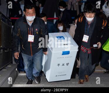 Seoul, Südkorea. April 2020. Mitarbeiter tragen Wahlurnen in eine Wahlstation in Seoul, Südkorea, 15. April 2020. Die südkoreanischen Wähler gingen am Mittwoch im Zuge des COVID-19-Ausbruchs zur Parlamentswahl, so die Nationale Wahlkommission. Die Wahl zur Wahl von 300 Mitgliedern der Nationalversammlung, die ab 6 Uhr Ortszeit begann, würde 12 Stunden lang in 14,330 Wahllokalen im ganzen Land dauern. Kredit: Lee Sang-ho/Xinhua/Alamy Live News Stockfoto