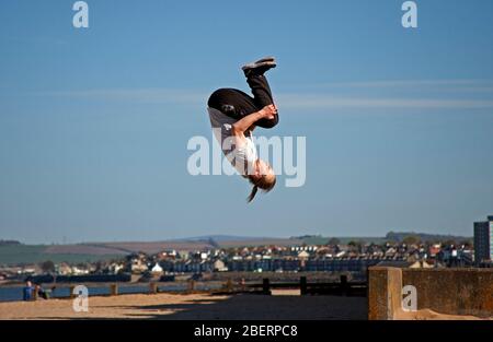 Portobello, Edinburgh, Schottland, Großbritannien. April 2020. Adam von Access Parkour, der führende Anbieter für den Unterricht in Parkour in Edinburgh und Schottland, limbing up mit einigen Zügen, während Klassen abgesagt werden und das Geschäft wegen Coronavirus Lockdown geschlossen ist. Parkour ist eine Trainingsdisziplin mit Bewegung, die aus militärischen Hindernisparcours Ausbildung entwickelt. Die Praktiker, die sogenannten Tracers oder Traceurs, wollen in einer komplexen Umgebung, ohne Hilfsausrüstung und auf die schnellste und effizienteste Weise von einem Punkt zum anderen gelangen. Quelle: Arch White/Alamy Live News Stockfoto