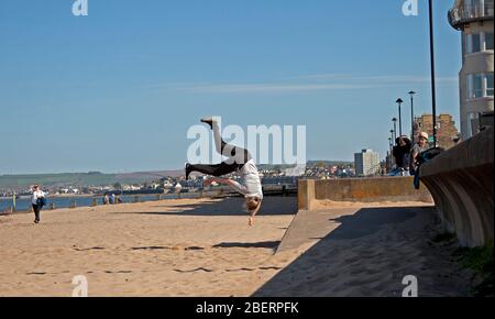 Portobello, Edinburgh, Schottland, Großbritannien. April 2020. Adam von Access Parkour, der führende Anbieter für den Unterricht in Parkour in Edinburgh und Schottland, limbing up mit einigen Zügen, während Klassen abgesagt werden und das Geschäft wegen Coronavirus Lockdown geschlossen ist. Parkour ist eine Trainingsdisziplin mit Bewegung, die aus militärischen Hindernisparcours Ausbildung entwickelt. Die Praktiker, die sogenannten Tracers oder Traceurs, wollen in einer komplexen Umgebung, ohne Hilfsausrüstung und auf die schnellste und effizienteste Weise von einem Punkt zum anderen gelangen. Quelle: Arch White/Alamy Live News Stockfoto