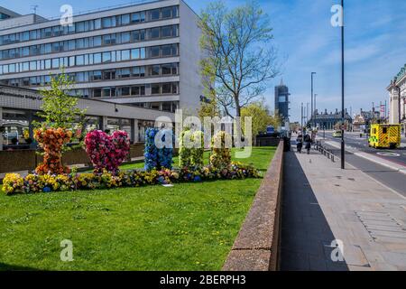 London, Großbritannien. April 2020. Passanten bewundern und fotografieren eine Blumenvererber, die "I Love (Heart) NHS" buchstabiert, vor dem St. Thomas' Hospital - die "Sperre" geht in London wegen des Coronavirus (Covid 19)-Ausbruchs weiter. Kredit: Guy Bell/Alamy Live News Stockfoto