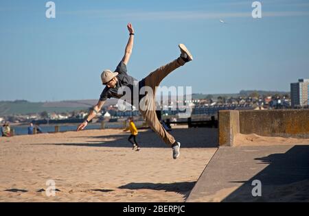 Portobello, Edinburgh, Schottland, Großbritannien. April 2020. Stephano von Access Parkour, der führende Anbieter für den Unterricht in Parkour in Edinburgh und Schottland, die mit einigen Zügen, während der Unterricht abgesagt werden und das Geschäft geschlossen ist wegen Coronavirus Lockdown. Parkour ist eine Trainingsdisziplin mit Bewegung, die aus militärischen Hindernisparcours Ausbildung entwickelt. Die Praktiker, die sogenannten Tracers oder Traceurs, wollen in einer komplexen Umgebung, ohne Hilfsausrüstung und auf die schnellste und effizienteste Weise von einem Punkt zum anderen gelangen. Quelle: Arch White/Alamy Live News Stockfoto