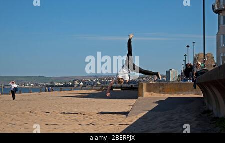 Portobello, Edinburgh, Schottland, Großbritannien. April 2020. Adam von Access Parkour, der führende Anbieter für den Unterricht in Parkour in Edinburgh und Schottland, limbing up mit einigen Zügen, während Klassen abgesagt werden und das Geschäft wegen Coronavirus Lockdown geschlossen ist. Parkour ist eine Trainingsdisziplin mit Bewegung, die aus militärischen Hindernisparcours Ausbildung entwickelt. Die Praktiker, die sogenannten Tracers oder Traceurs, wollen in einer komplexen Umgebung, ohne Hilfsausrüstung und auf die schnellste und effizienteste Weise von einem Punkt zum anderen gelangen. Quelle: Arch White/Alamy Live News Stockfoto