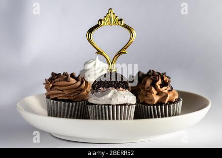 Verschiedene Cupcakes in einem Teller auf weißem Hintergrund Stockfoto