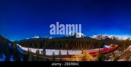 Nachtzug im Mondlicht bei Morant's Curve im Banff National Park, Kanada. Stockfoto