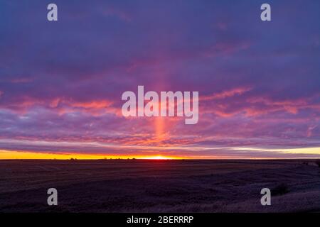 Eine leichte Säule vor der aufgehenden Sonne in Alberta, Kanada. Stockfoto