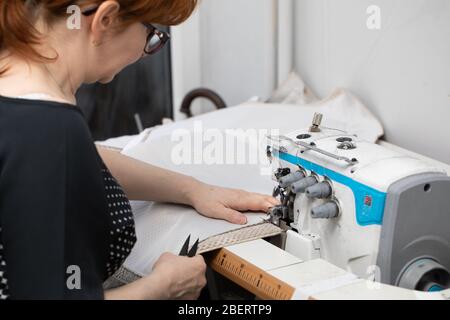 Eine Näherin mit langjähriger Erfahrung im Mittelalter arbeitet schnell und effizient. Stockfoto