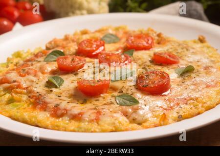 Vegetarische Blumenkohl-Pizza über einem Holztisch Stockfoto