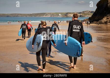 Eine Gruppe Surfer auf dem Weg zum Meer. Stockfoto