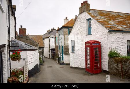 Eine rote Callbox in einer typischen Gasse im Fischerdorf Port Isaac. Stockfoto