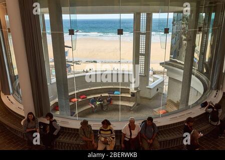 Blick von der Tate St Ives auf das Atrium im Eingangsbereich hinter dem Strand und dem Meer. Stockfoto