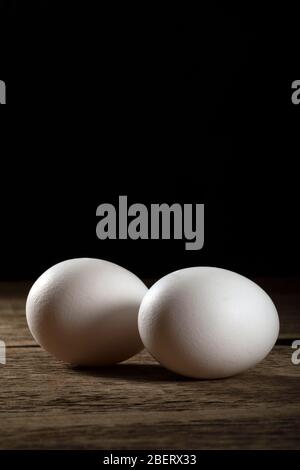 Zwei frische weiße Eier auf einem Holztisch. Stockfoto
