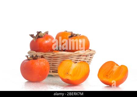 Frische Persimmon-Frucht auf einem nassen weißen Hintergrund Stockfoto