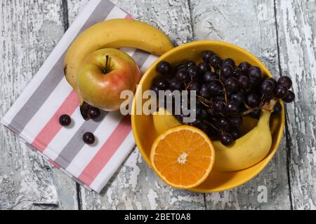 Frisches Obst auf gelbem Teller und Handtuch. Multivitamin-Cocktail. Gesunde Lebensweise Stockfoto