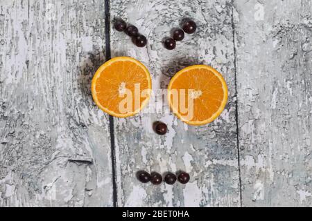 Rote Trauben und Orange in Form eines Lächelns. Gesunde Lebensweise. Smiley Stockfoto