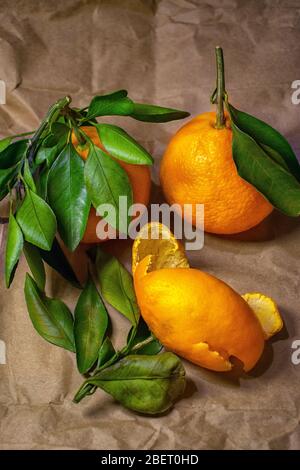 Frische Mandarinen liegen auf braunem Papier auf dem Tisch Stockfoto
