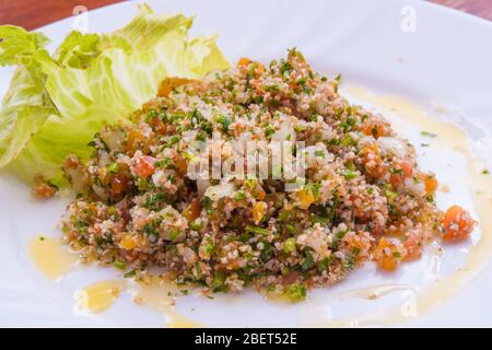 Traditionelle libanesische Tabbouleh mit Schnittlauch, Zwiebel, Tomaten und Öl Stockfoto