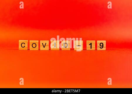 Das Konzept einer Pandemie und eines Virus ist ein Coronavirus Wort aus Holzbuchstaben. Coronavirus Text auf rotem Hintergrund. Covid19 Stockfoto