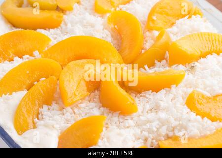 Dessert von süßem Pfirsich mit geriebener Kokosnuss Stockfoto