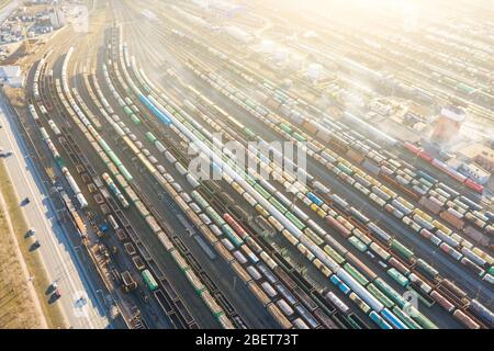 Luftaufnahme der Eisenbahnschienen lange Züge, Fracht Sortierstation. Viele verschiedene Eisenbahnwaggons mit Fracht und Rohstoffen Stockfoto