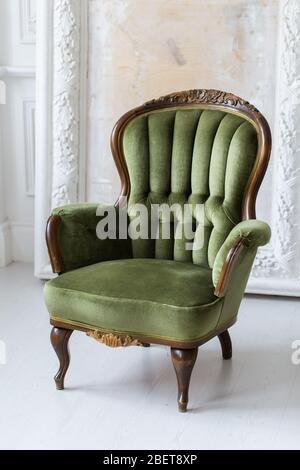 Vintage Luxus grünen Sessel in weißen Raum über Wand Basrelief Stuck Zierleisten-Jahrgang Designelemente Stockfoto