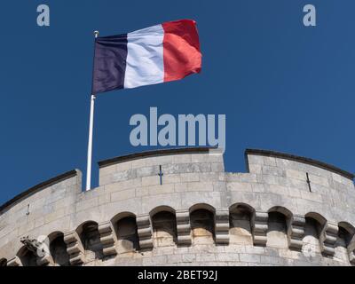 Frankreich-Flagge winkt vor blauem Himmel am La Rochelle Tower Stockfoto