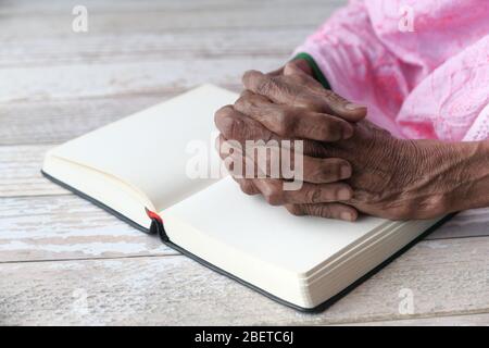 Nahaufnahme der Hände älterer Frau auf bibel Stockfoto