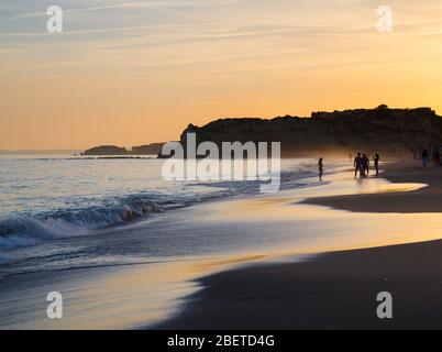 Portugal, Algarve, die besten Strände von Portimao, Praia da Rocha, Sonnenuntergang über dem Atlantischen Ozean, Menschen an der Küste des Abendatlantiks, die Mo Stockfoto