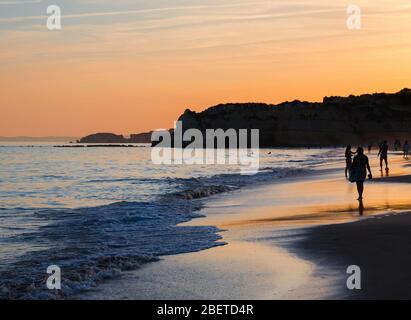 Portugal, Algarve, die besten Strände von Portimao, Praia da Rocha, Sonnenuntergang über dem Atlantischen Ozean, Menschen an der Küste des Abendatlantiks, die Mo Stockfoto