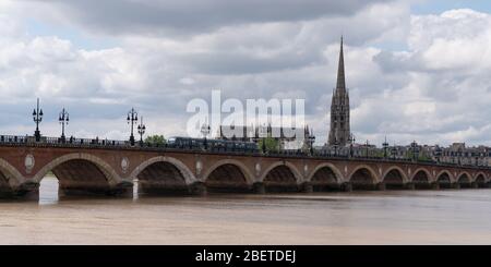 Bordeaux, Gironde / France - 05 26 2019 : die Straßenbahn fährt über den Pont de Pierre in der Garonne und der Basilika Saint Michel Bordeaux Stockfoto