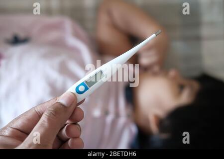 Mutter misst die Temperatur ihres kranken Kindes. Stockfoto