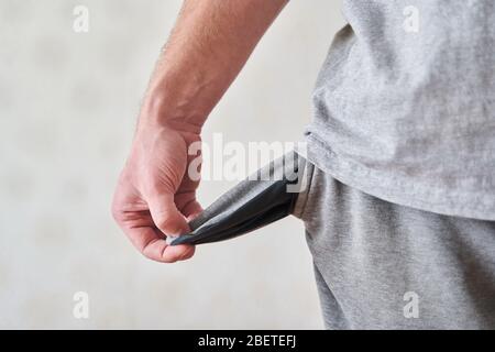 Umgekehrte leere Taschen. Der junge Mann stellte leere Jeans-Taschen aus. Stockfoto