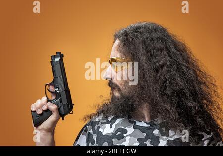 Porträt eines dünnen Kerl poiting eine Waffe - isoliert Stockfoto