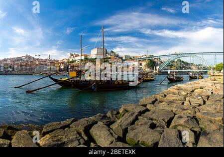 Portugal, bunte Stadtlandschaft Porto, Holzboote mit Wein-Portweinfässer auf dem Douro-Fluss, Panoramablick auf die Altstadt Porto, die Eiffelturm-Brücke Stockfoto