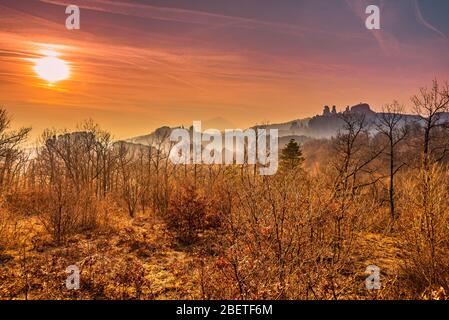 Unglaublicher Hazy Sonnenuntergang über den Silhouetten der seltsam geformten Sandsteinfelsen in der historischen Stadt Belogradchik, Nordwestbulgarien Stockfoto