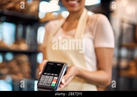 Junge Erwachsene Frau mit Wireless-Terminal in den Händen Stockfoto